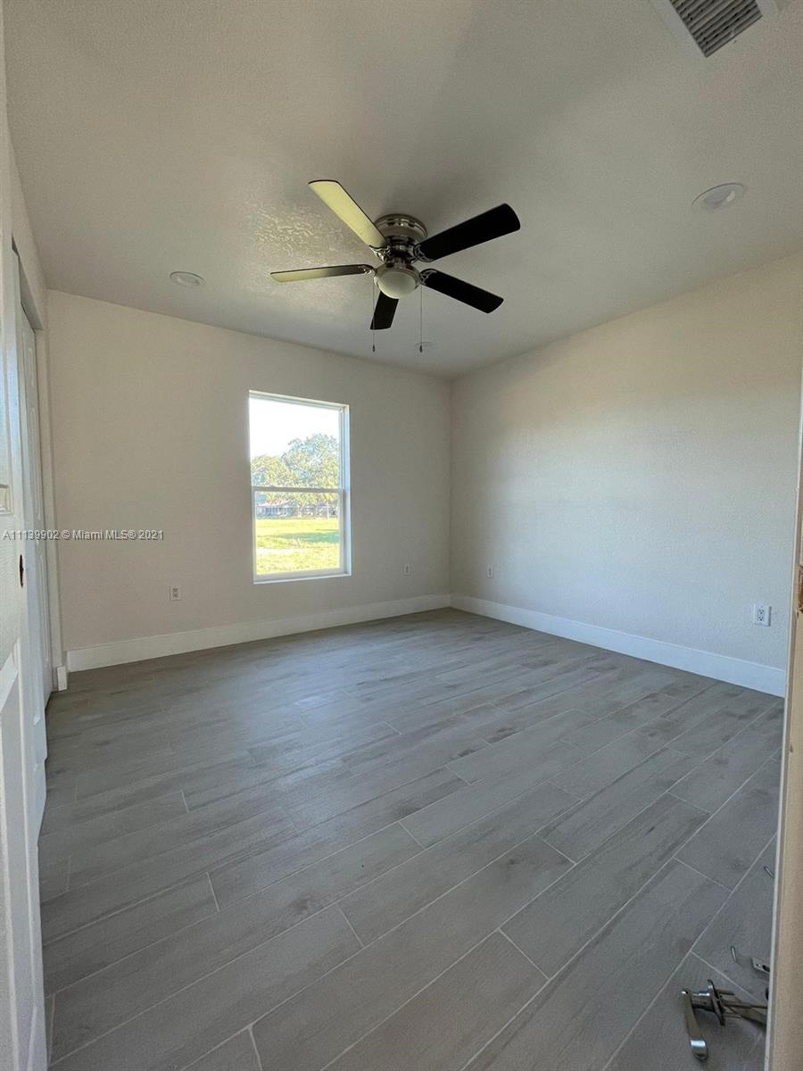 417 Cherry Tree Drive Sebring, FL 33876 - Photo 37 of 39 an empty room with windows and fan