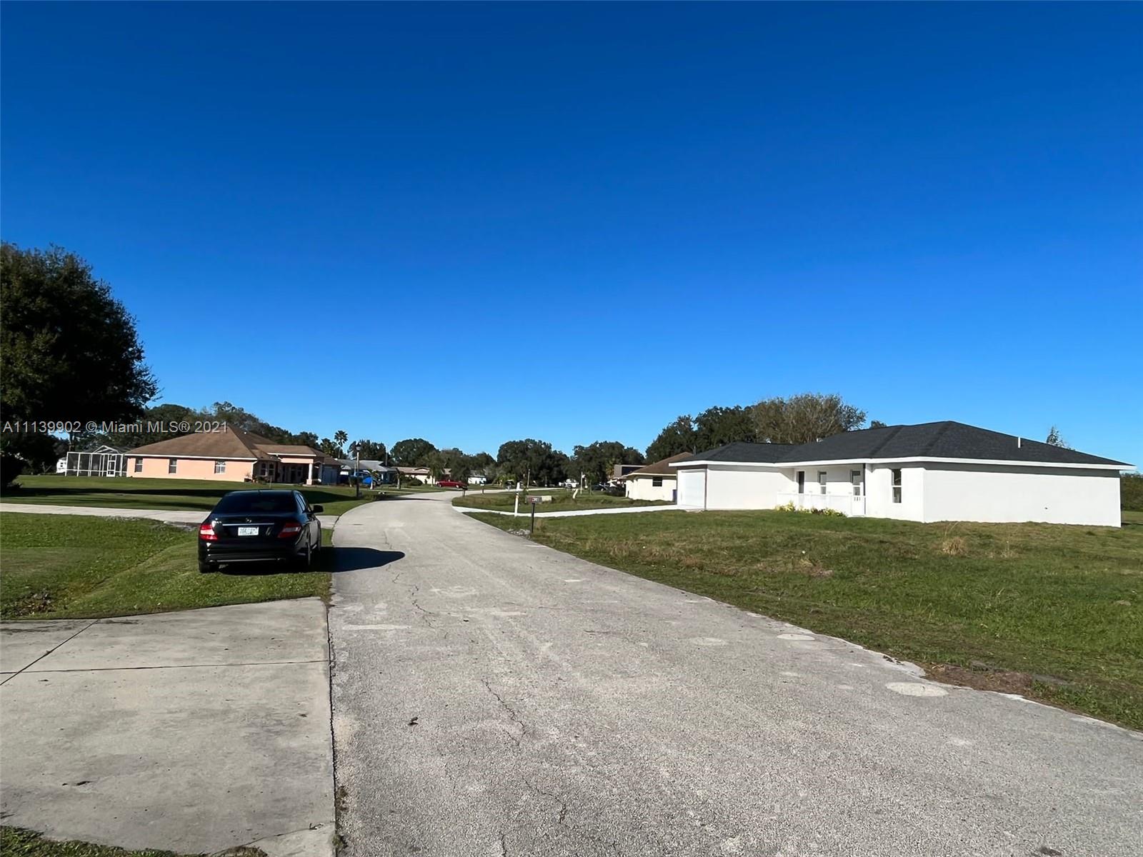 417 Cherry Tree Drive Sebring, FL 33876 - Photo 9 of 39 a view of a street with a car parked in front of it