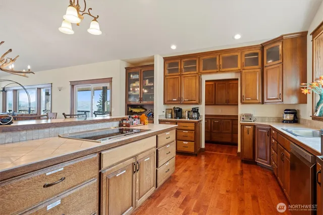 a kitchen with stainless steel appliances granite countertop a refrigerator a sink dishwasher a oven with white cabinets and wooden floor