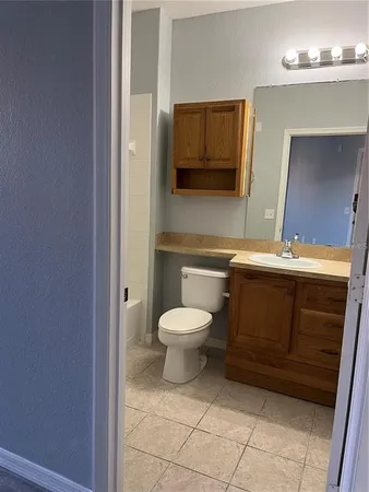 a bathroom with a toilet a sink and mirror