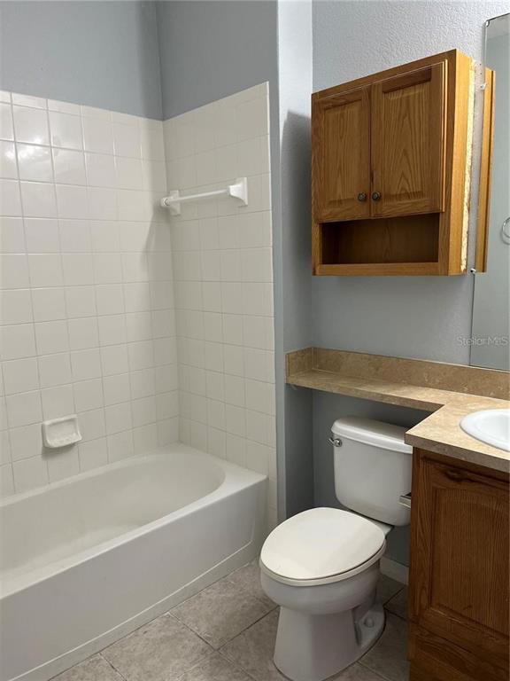 6157 Metrowest Boulevard, Unit 101 Orlando, FL 32835 - Photo 5 of 10 a bathroom with a sink a toilet and bathtub