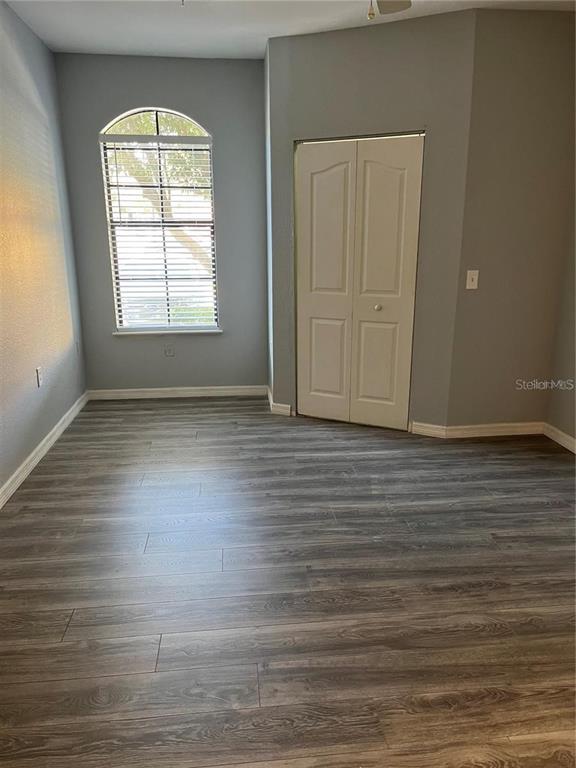 6157 Metrowest Boulevard, Unit 101 Orlando, FL 32835 - Photo 6 of 10 an empty room with wooden floor and windows