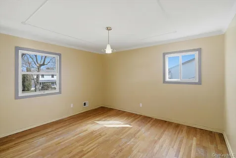 a view of empty room with wooden floor