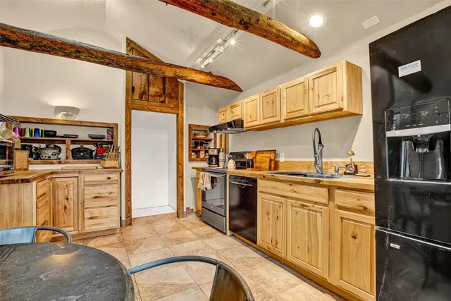 a kitchen with stainless steel appliances a dining table chairs and granite counter tops