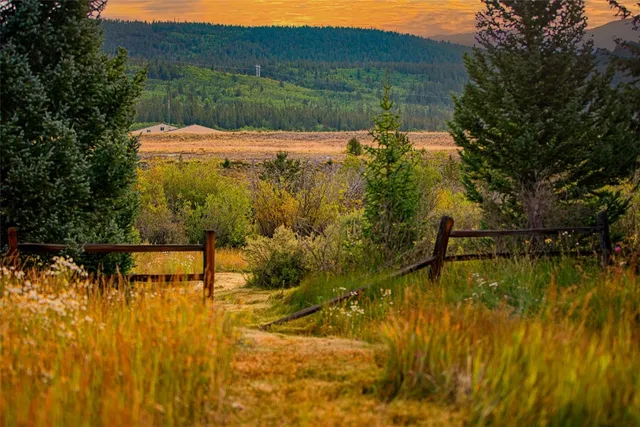 a kitchen with stainless steel appliances granite countertop a refrigerator a stove and white cabinets with wooden floors