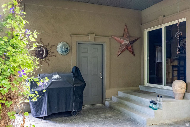 288 525 South Providence, UT 84332 - Photo 45 of 71 Covered patio area featuring a textured stucco exterior, a gray paneled door, and concrete steps