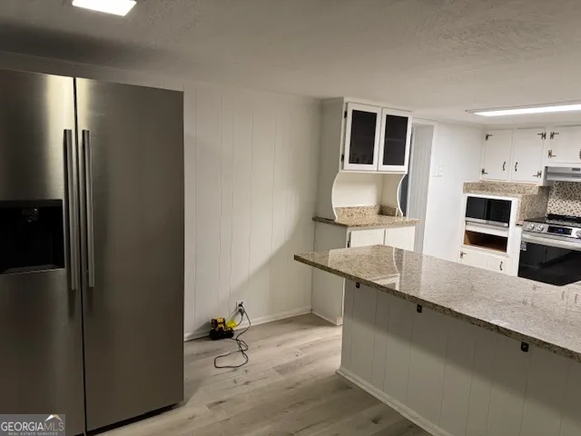 a kitchen with stainless steel appliances granite countertop a refrigerator and a sink