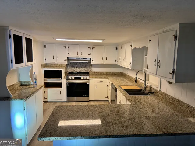a kitchen with stainless steel appliances granite countertop a stove and a sink