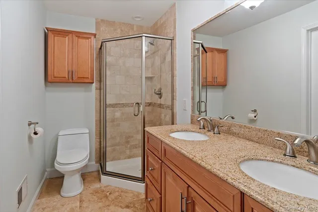 a bathroom with a granite countertop sink toilet and shower