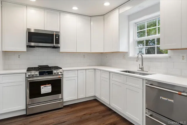 a kitchen with stainless steel appliances granite countertop a sink and a stove