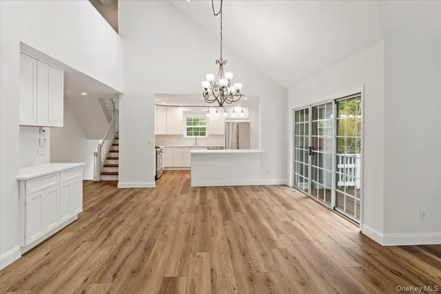 a view of a room with wooden floor and a kitchen