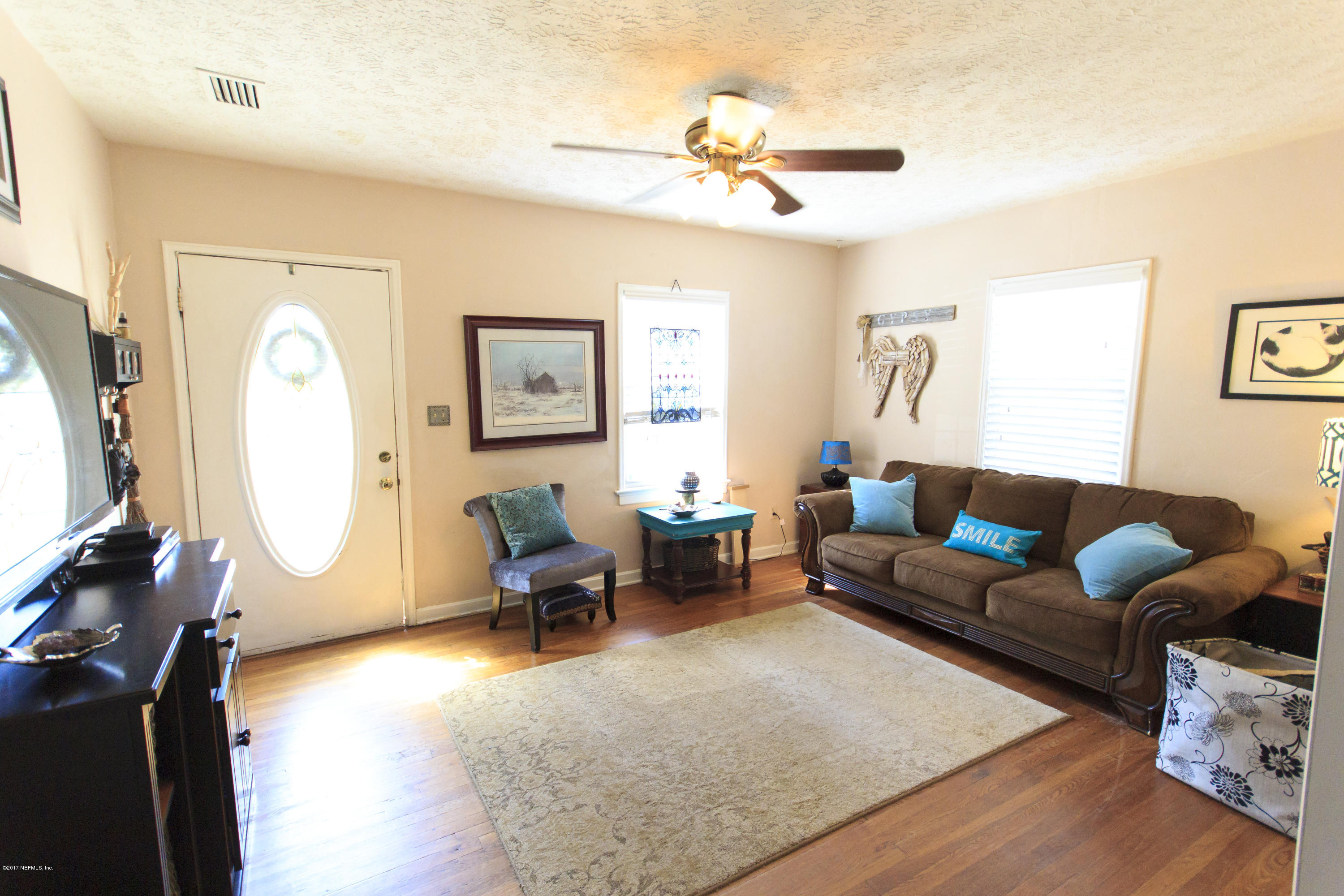 4923 Dundee Road Jacksonville, FL 32210 - Photo 4 of 14 a living room with furniture a rug and a chandelier