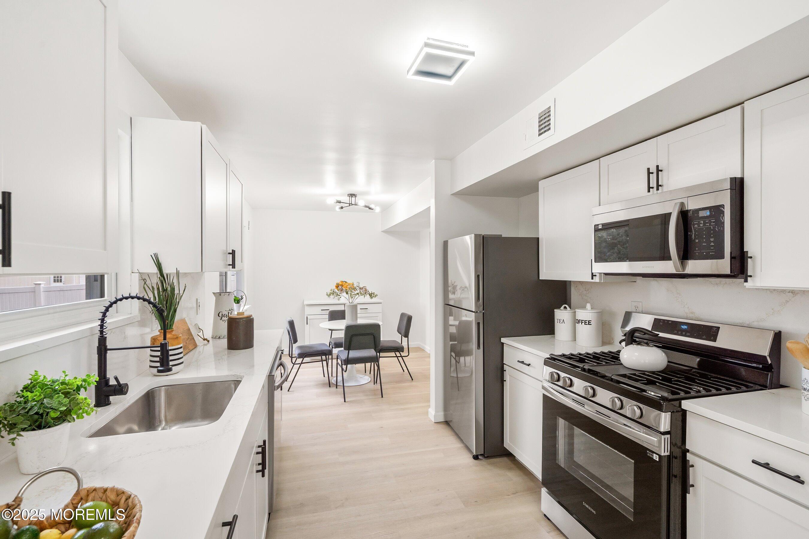 944 Yellowbank Road Toms River, NJ 08753 - Photo 6 of 33 a kitchen with stainless steel appliances a stove a sink a microwave a refrigerator and cabinets