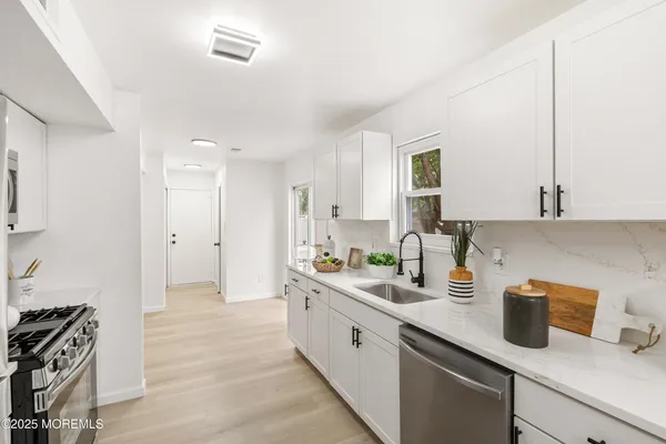 a kitchen with sink a stove and cabinets