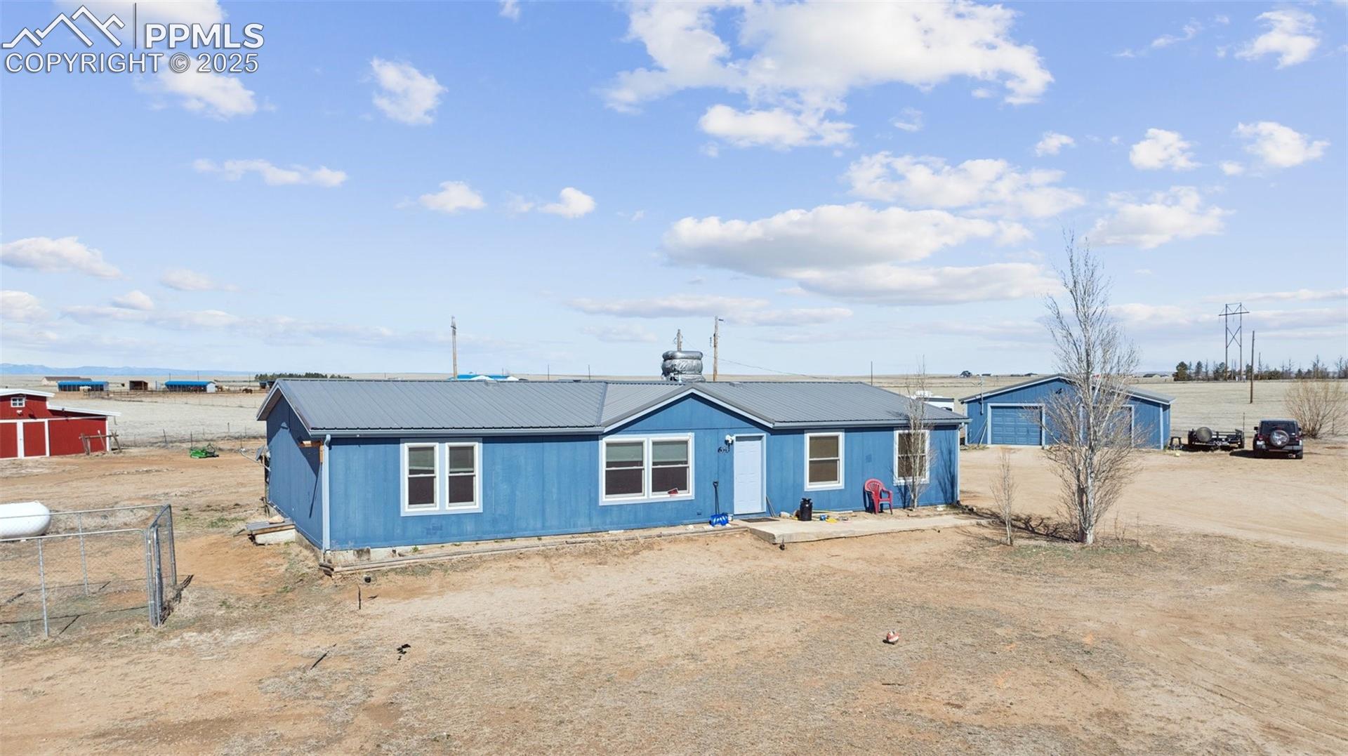 610 Awesome View Yoder, CO 80864 - Photo 1 of 20 View of front of property featuring an outbuilding, driveway, fence, and metal roof