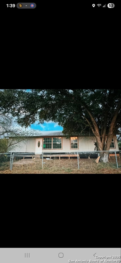 a view of a big yard with a house in the background