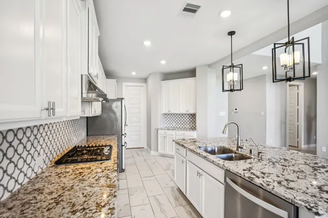 a kitchen with stainless steel appliances granite countertop a sink stove and refrigerator