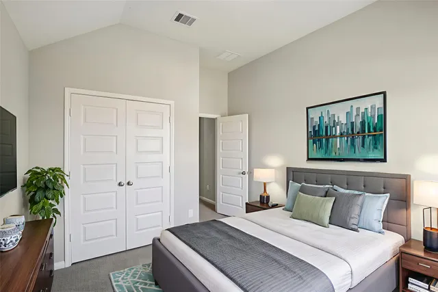 a bedroom with a bed and a potted plant