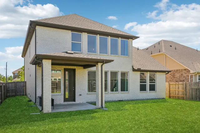 a view of a house with brick walls and a yard with stairs