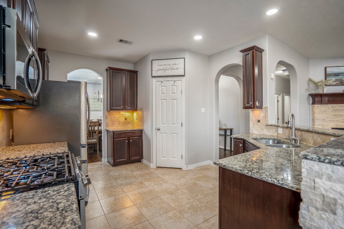 27135 Cottage Stream Lane Fulshear, TX 77441 - Photo 14 of 42 Well appointed kitchen with granite countertops, stainless steel appliances, ample cabinetry and a functional layout for everyday cooking.