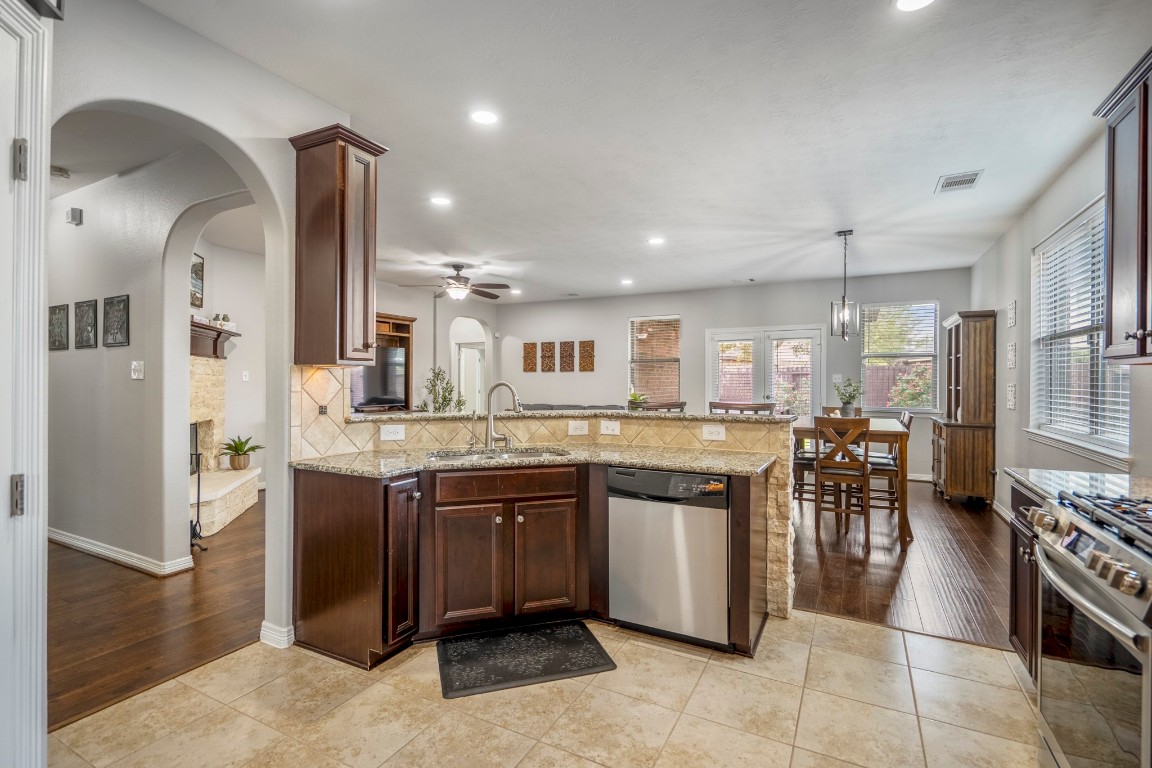 27135 Cottage Stream Lane Fulshear, TX 77441 - Photo 16 of 42 Open kitchen with granite counters, stainless steel appliances and a large island overlooking the dining and living areas.