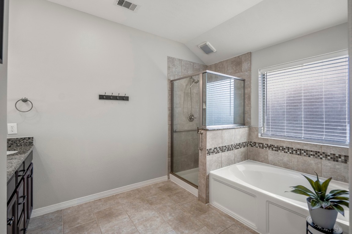 27135 Cottage Stream Lane Fulshear, TX 77441 - Photo 21 of 42 Spacious primary bathroom featuring a soaking tub, separate glass enclosed shower and natural light for a bright, spa-like feel.