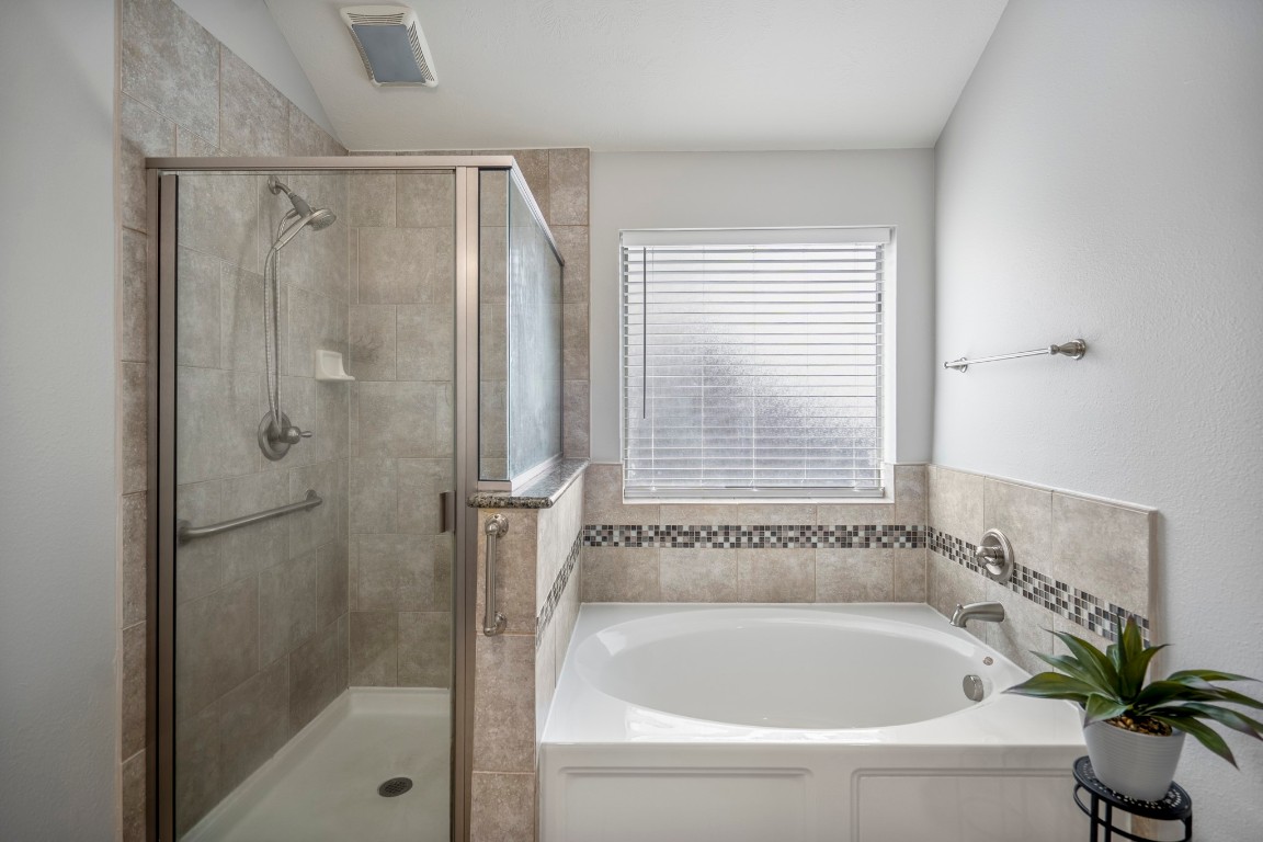 27135 Cottage Stream Lane Fulshear, TX 77441 - Photo 23 of 42 Unwind in this spa-inspired primary bath with a soaking tub, separate shower and soft natural light.
