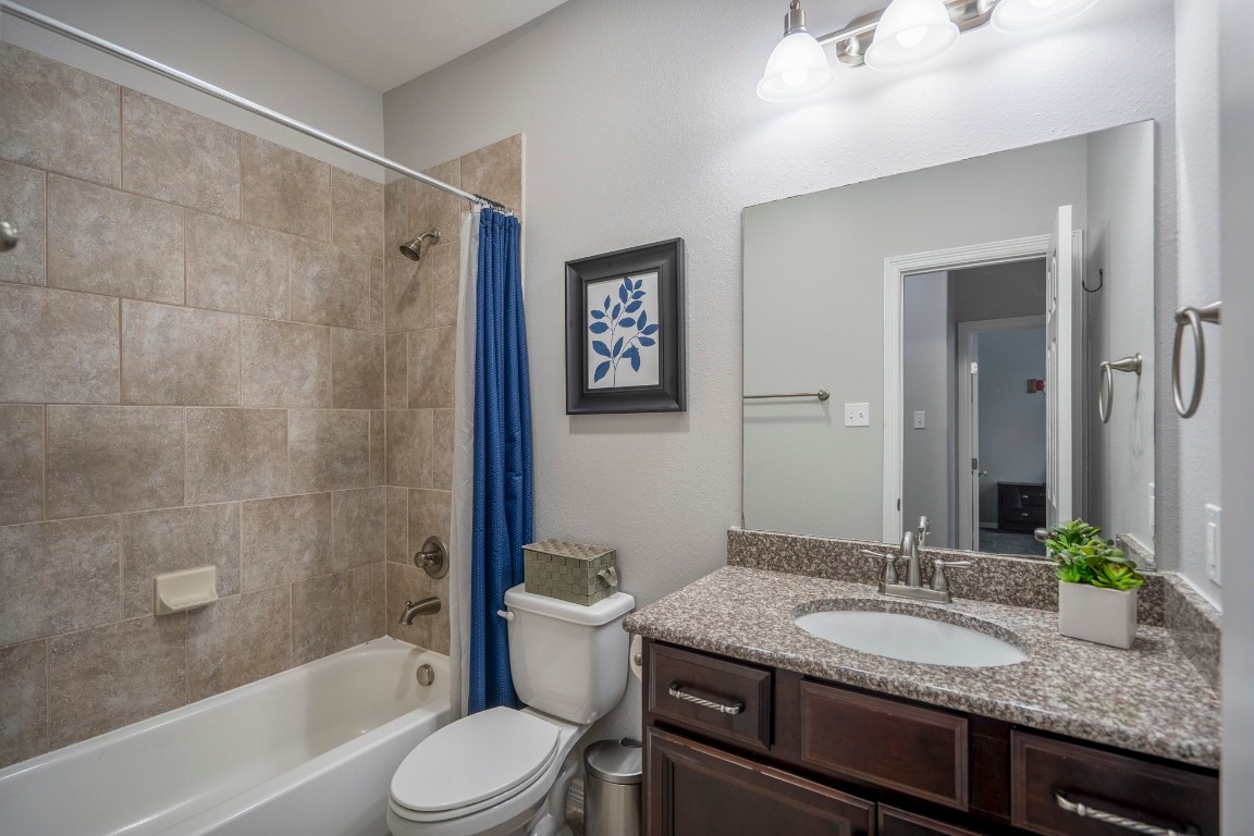 27135 Cottage Stream Lane Fulshear, TX 77441 - Photo 26 of 42 Secondary bathroom with granite countertops, tile surround tub/shower and a clean functional layout.