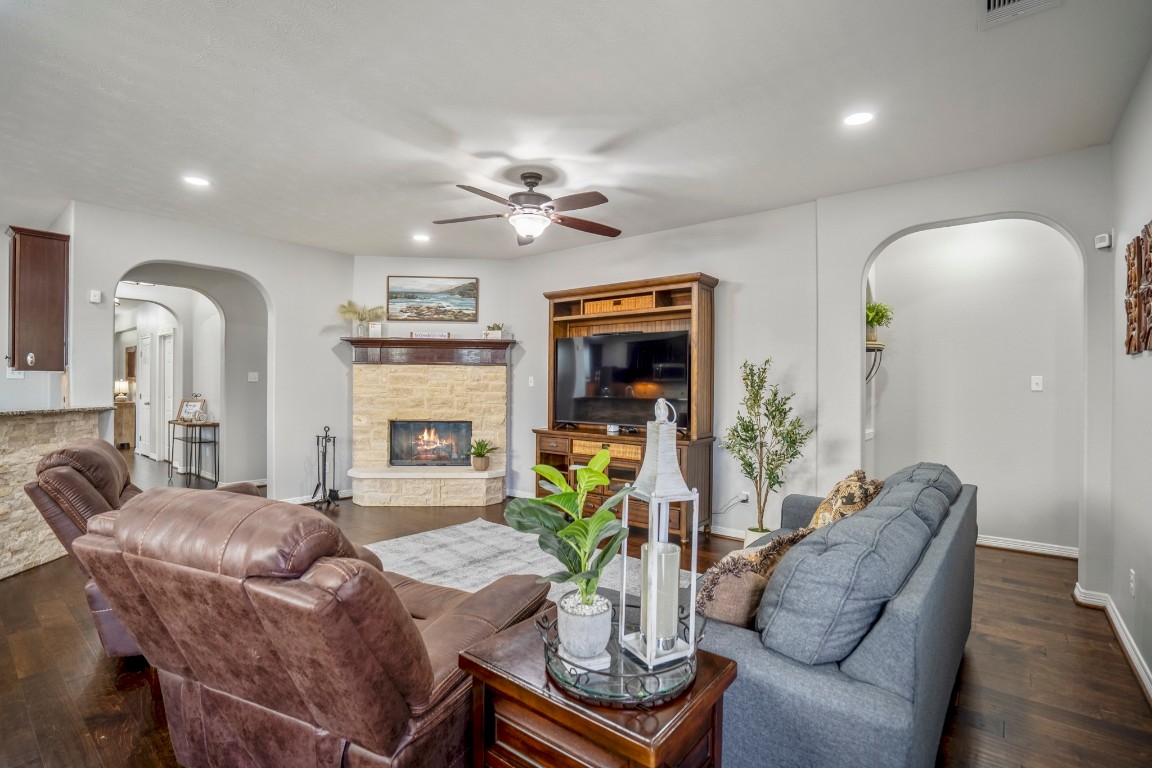 27135 Cottage Stream Lane Fulshear, TX 77441 - Photo 8 of 42 Spacious living room with an open layout, rich flooring, and seamless flow to the kitchen and main living areas - perfect for entertaining.