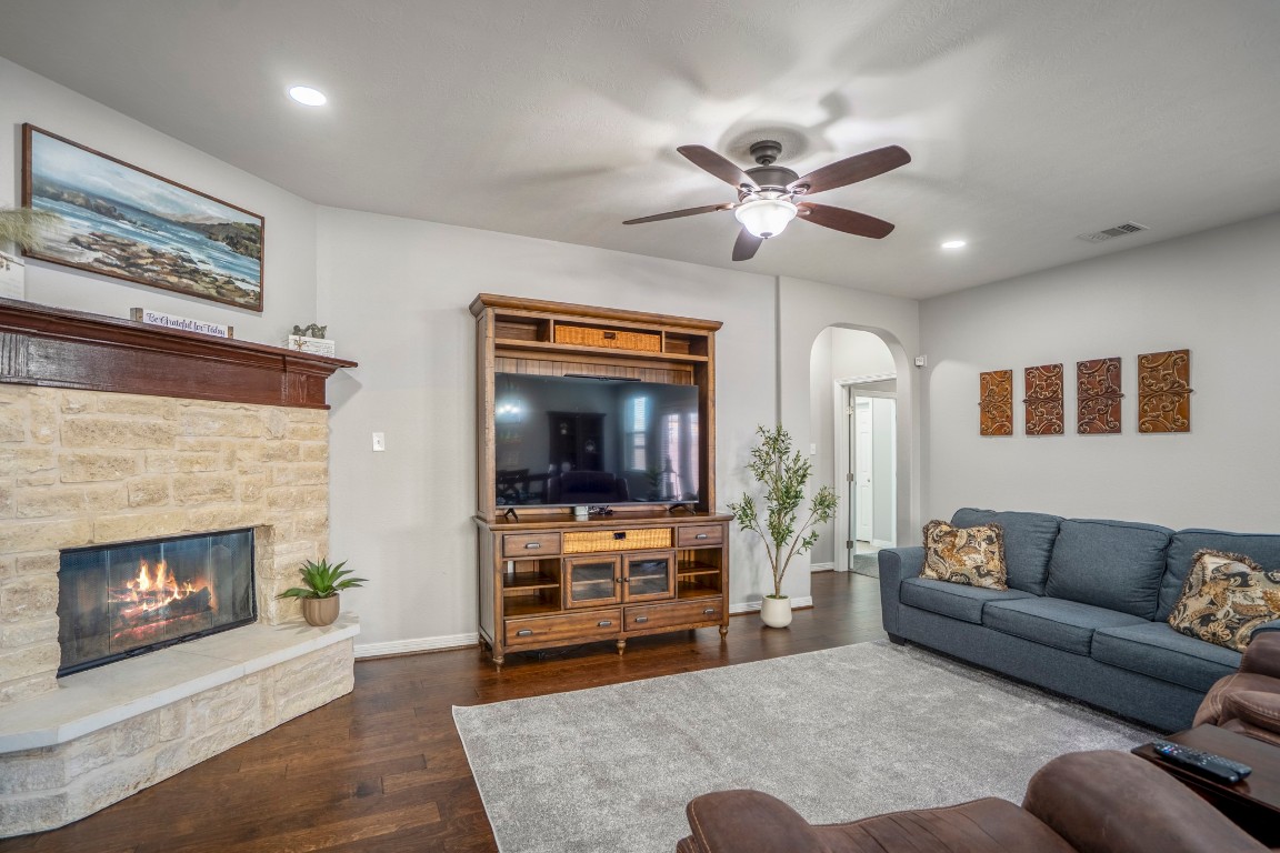 27135 Cottage Stream Lane Fulshear, TX 77441 - Photo 9 of 42 Cozy living area featuring a beautiful fireplace, abundant natural light, and plenty of space to relax or gather with family and friends.