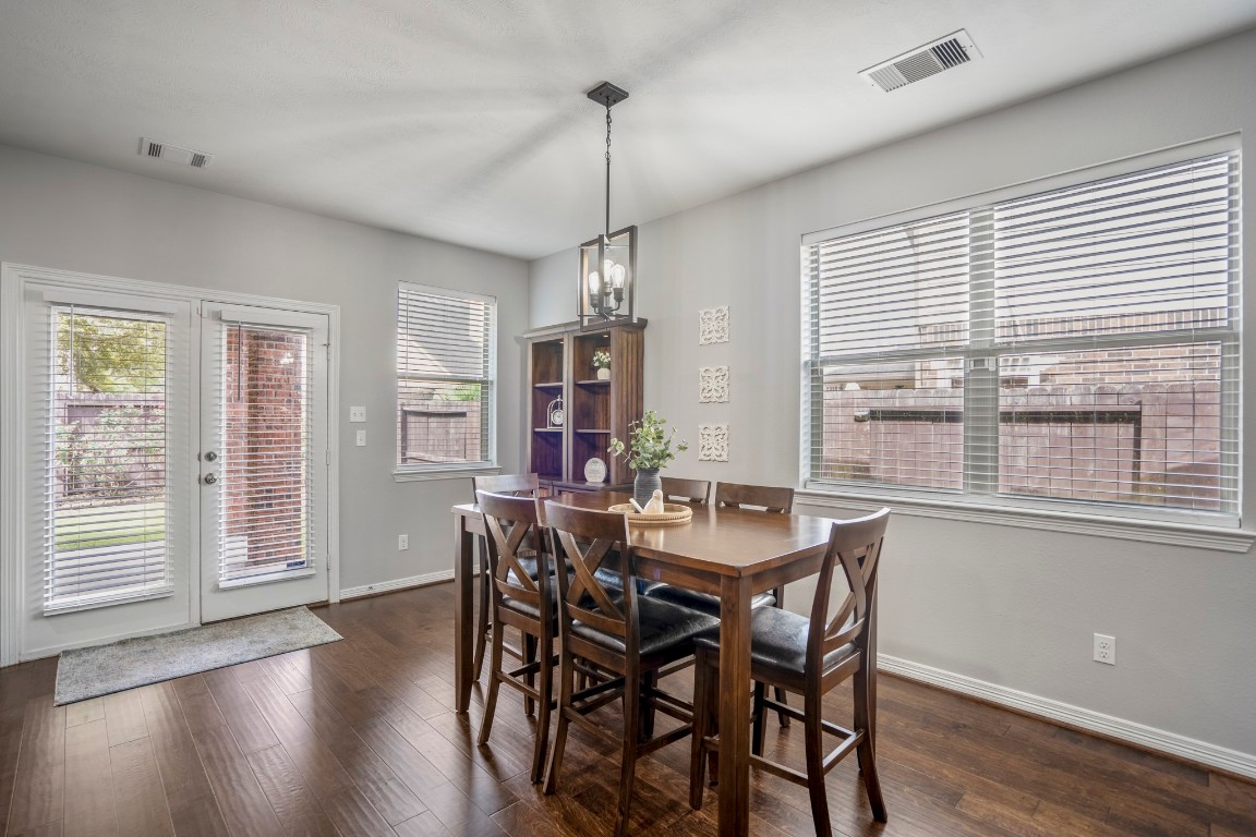 27135 Cottage Stream Lane Fulshear, TX 77441 - Photo 10 of 42 Bright dining area with abundant natural light, wood flooring, and direct access to the backyard - perfect for everyday meals and entertaining.