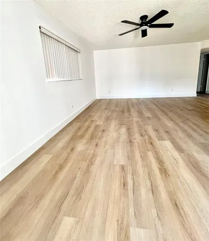 a view of a big room with wooden floor and windows in a room