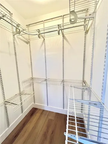 a view of a walk in closet and wooden floor