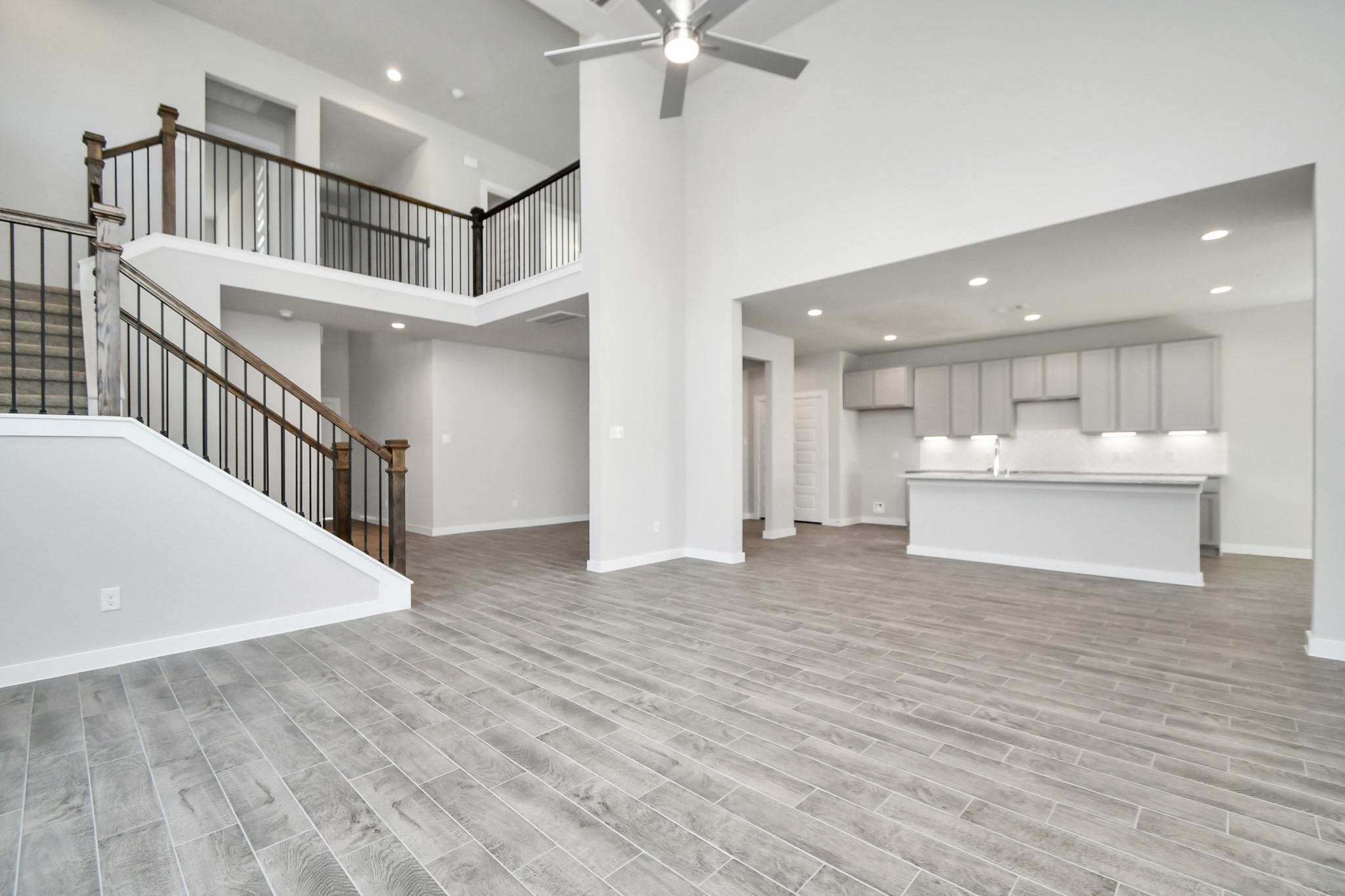 2938 Bury Park Dr Spring Spring, TX 77373 - Photo 14 of 30 Gather the family and guests together in your lovely living room! Featuring soaring high ceilings, recessed lighting, ceiling fan, custom paint, gorgeous floors, and large windows that provide plenty of natural lighting throughout the day. Sample photo of completed home with similar floor plan. As-built interior colors and selections may vary.