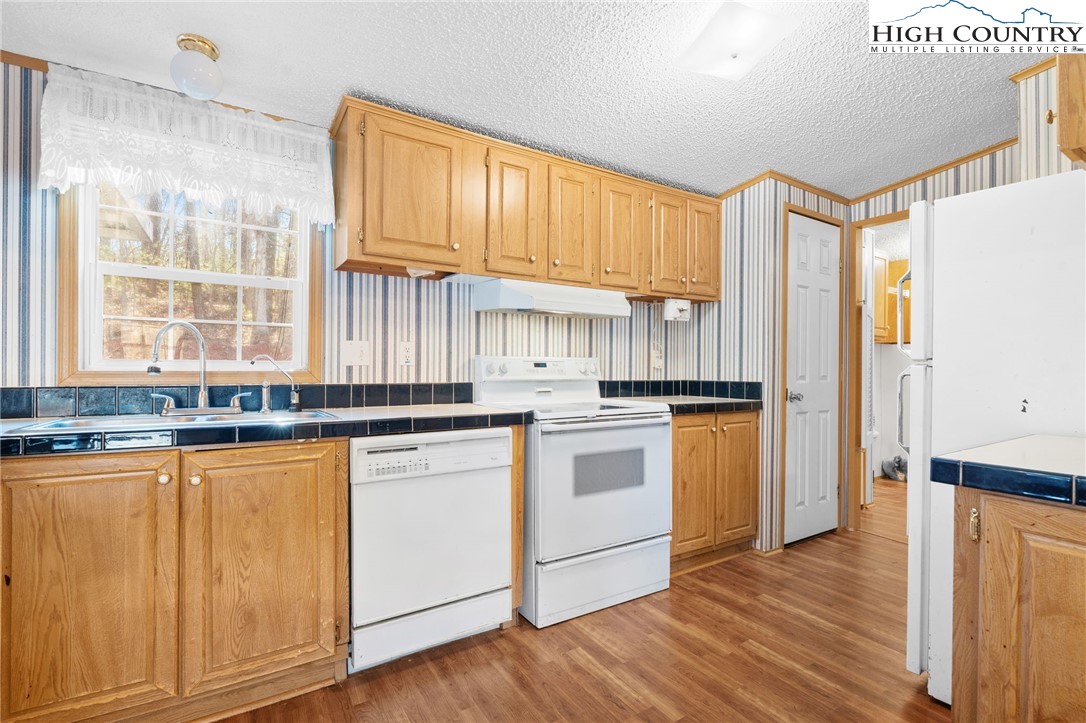 3435 Nelson Lane Morganton, NC 28655 - Photo 15 of 30 a kitchen with granite countertop wooden floors and white stainless steel appliances