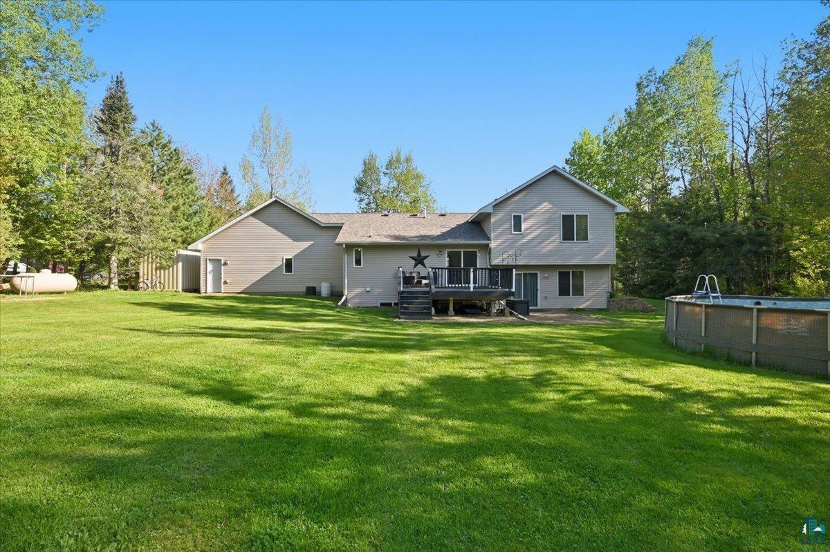 47 Amy Lane Esko, MN 55733 - Photo 2 of 33 Spacious backyard featuring a manicured lawn, an elevated deck, and mature trees providing natural privacy