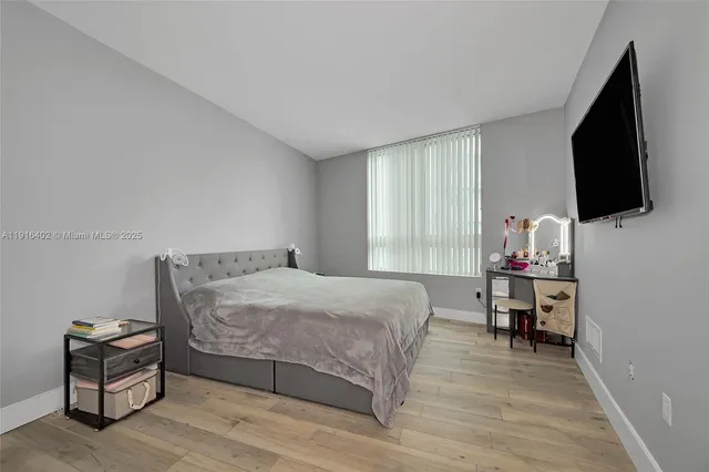 a bedroom with a bed and flat screen tv