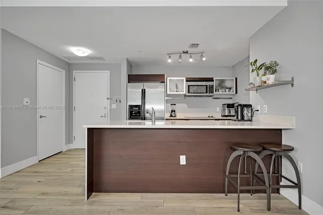 a kitchen with stainless steel appliances granite countertop a sink a stove and a wooden floors