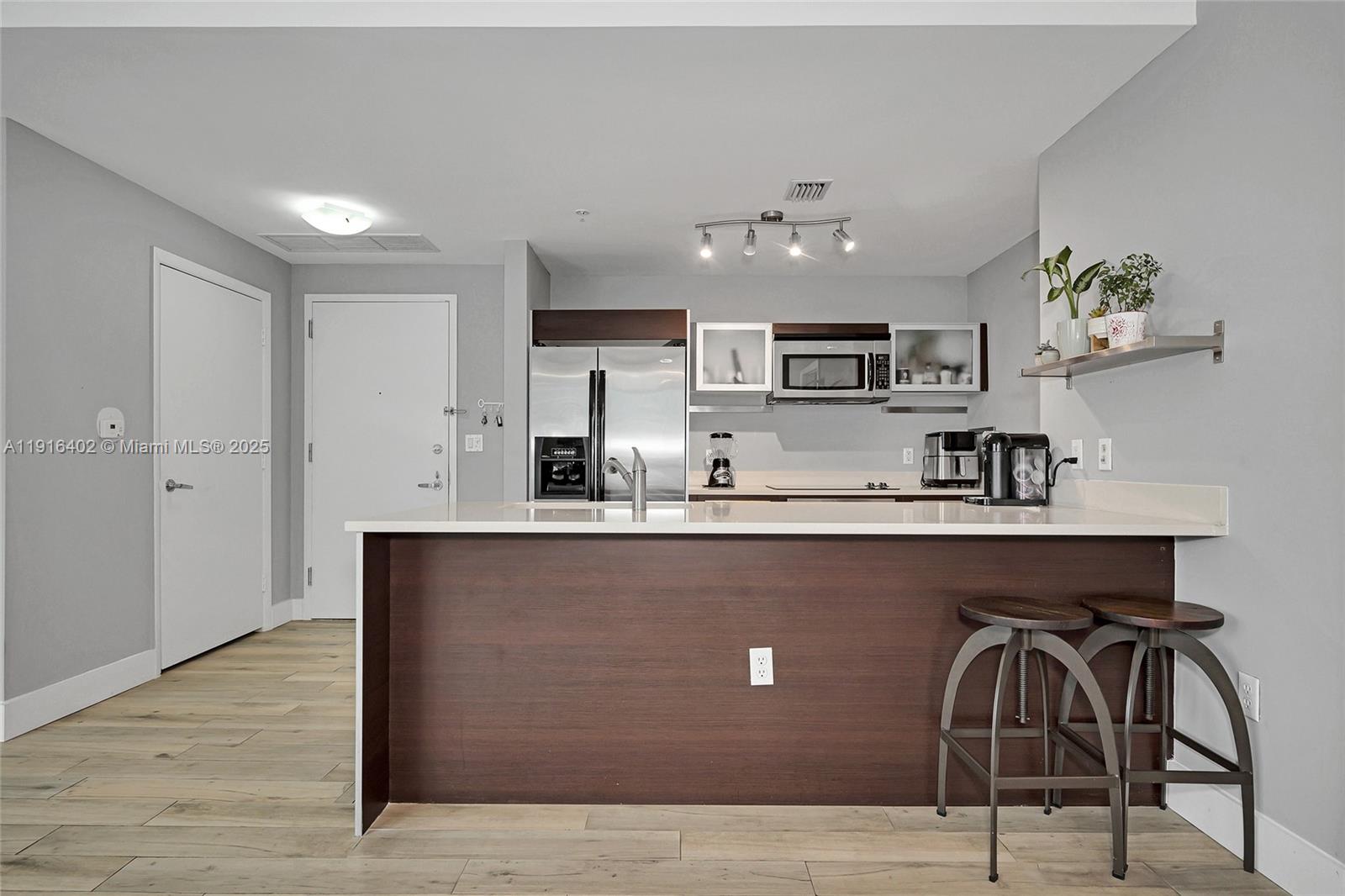 1900 North Bayshore Drive, Unit 4019 Miami, FL 33132 - Photo 2 of 31 a kitchen with stainless steel appliances granite countertop a sink a stove and a wooden floors