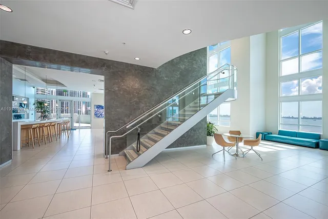 a dining room with furniture and large windows