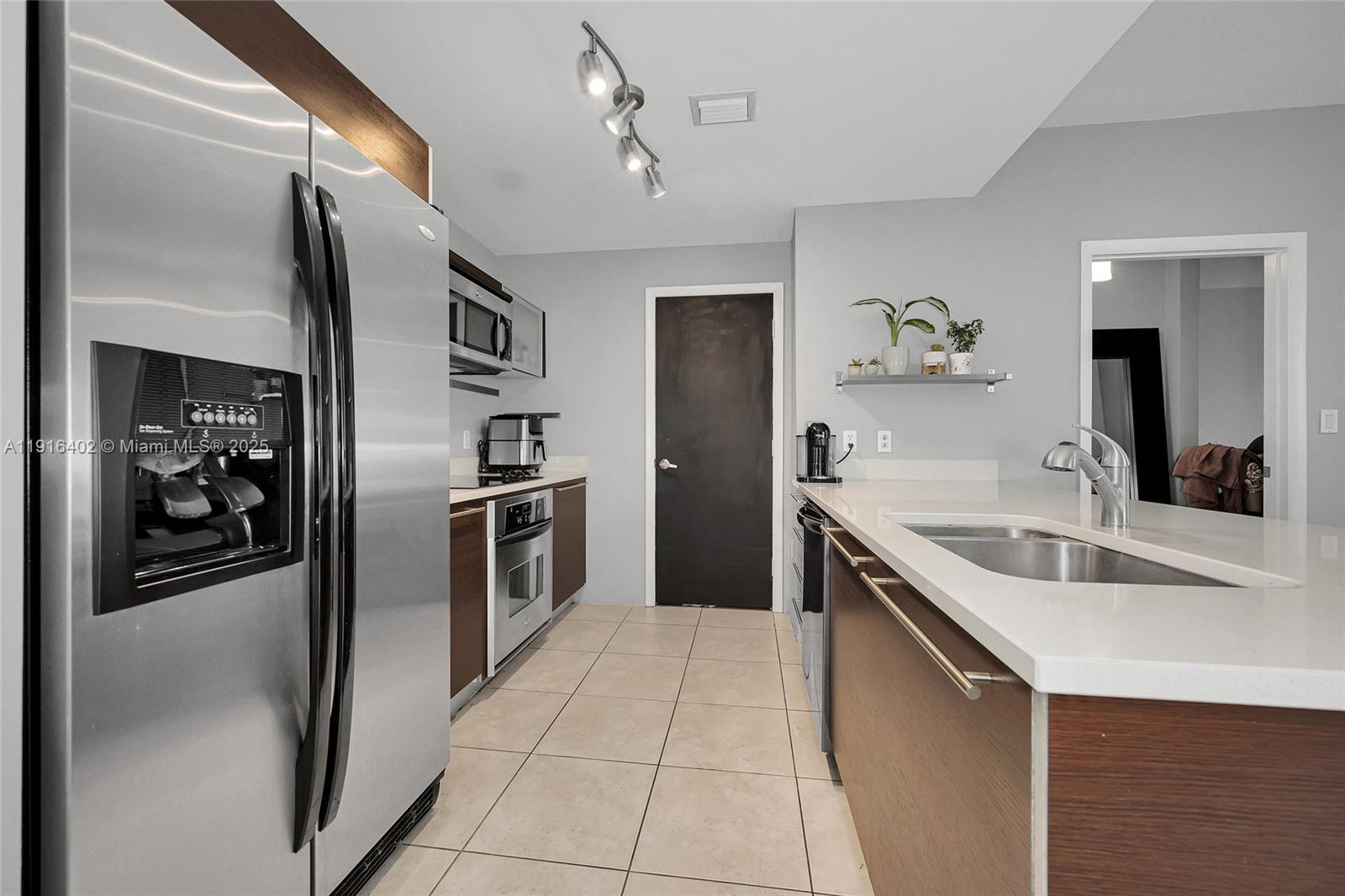 1900 North Bayshore Drive, Unit 4019 Miami, FL 33132 - Photo 7 of 31 a kitchen with stainless steel appliances granite countertop a sink and a refrigerator