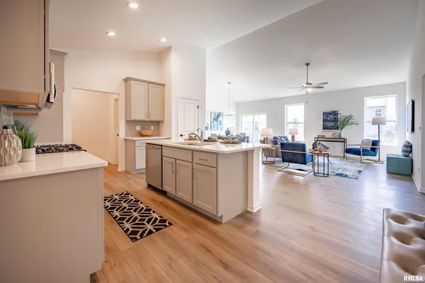 a kitchen with a sink stove and wooden floor