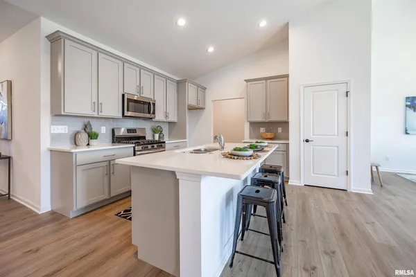 a kitchen with kitchen island white cabinets and stainless steel appliances