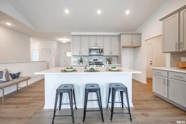 a kitchen with a table chairs refrigerator and cabinets