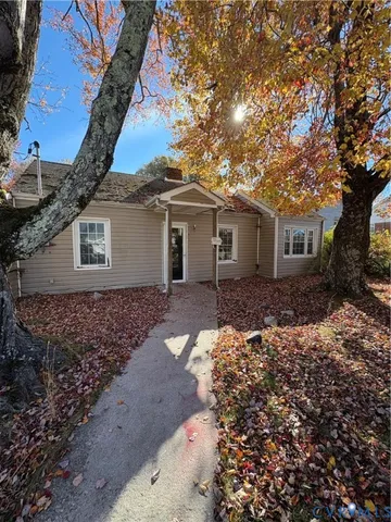 a white house with a large tree in front of it