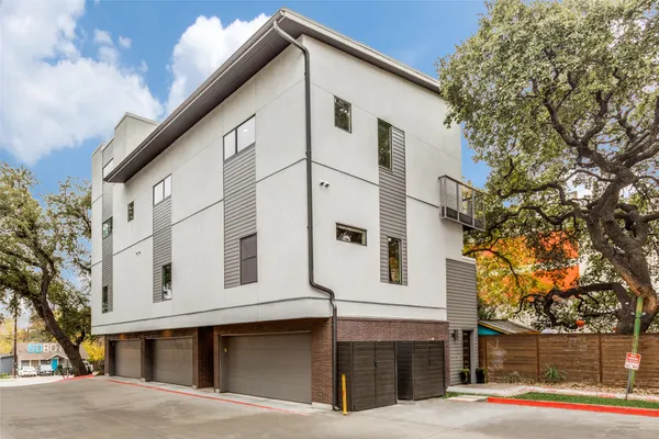 a view of a white house with a large tree