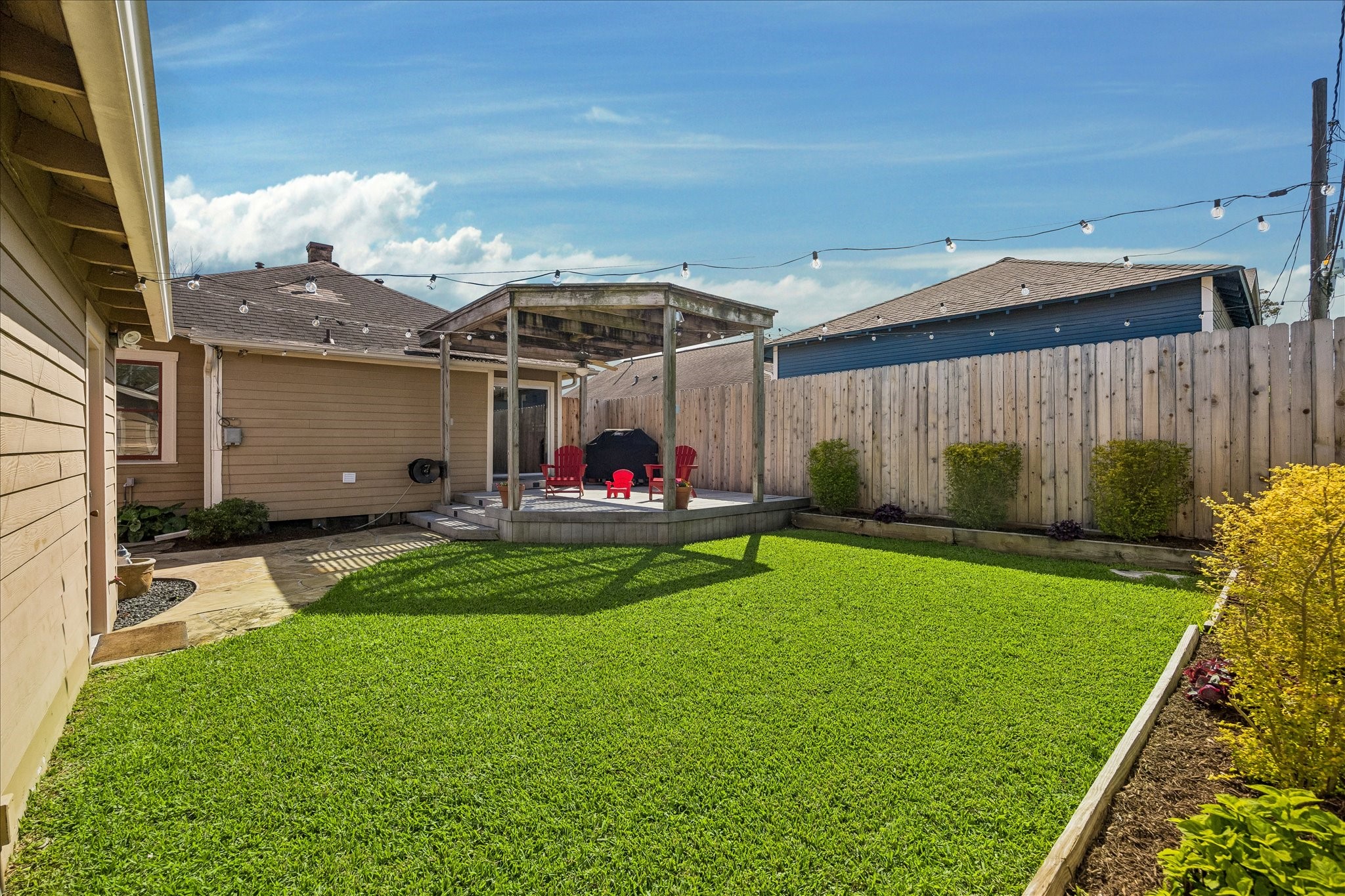 919 Key Street Houston, TX 77009 - Photo 26 of 39 A refined outdoor setting designed for both quiet moments and effortless entertaining. The manicured lawn offers a sense of openness, while the pergola creates a natural focal point. Perfectly suited for intimate gatherings beneath soft ambient lighting. Every element feels intentional, from the clean landscaping lines to the seamless connection between indoor comfort and outdoor living.