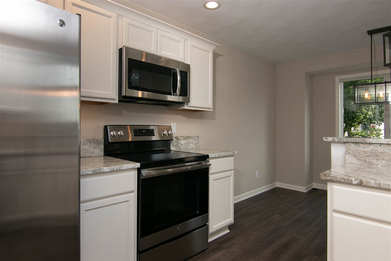 313 East Pershing Road Stillman Valley, IL 61084 - Photo 5 of 21 a kitchen with stainless steel appliances granite countertop a stove microwave and sink