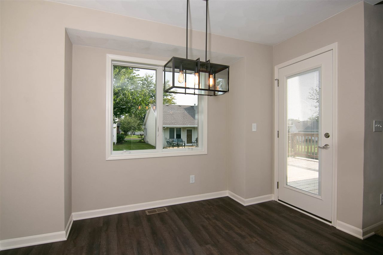 313 East Pershing Road Stillman Valley, IL 61084 - Photo 7 of 21 an empty room with wooden floor chandelier and windows