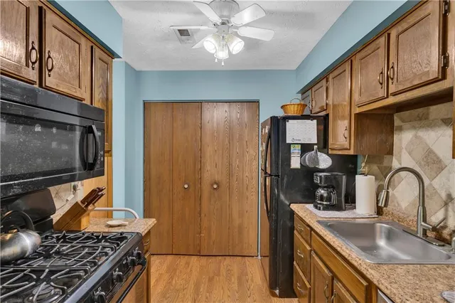 a kitchen with stainless steel appliances granite countertop a sink stove and cabinets